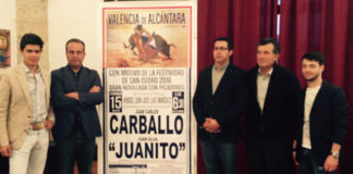 Los dos novilleros y el empresario posando con miembros de la Corporación ante el cartel de la novillada